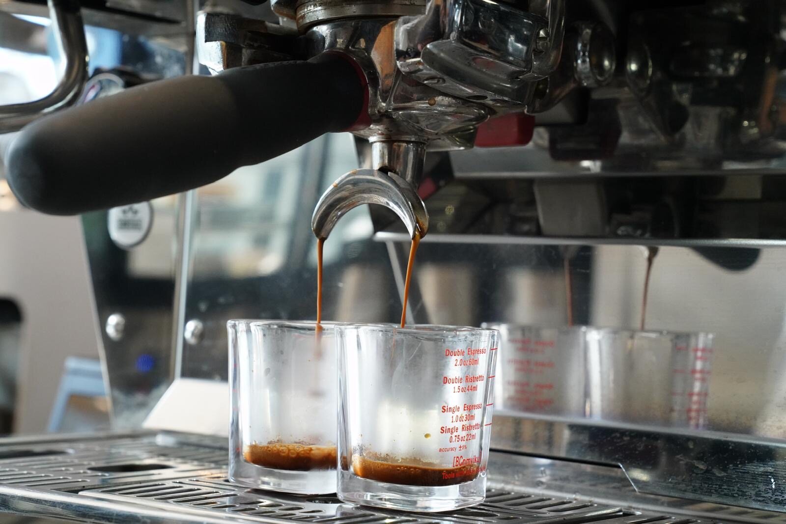 A double espresso pulling into shot glasses