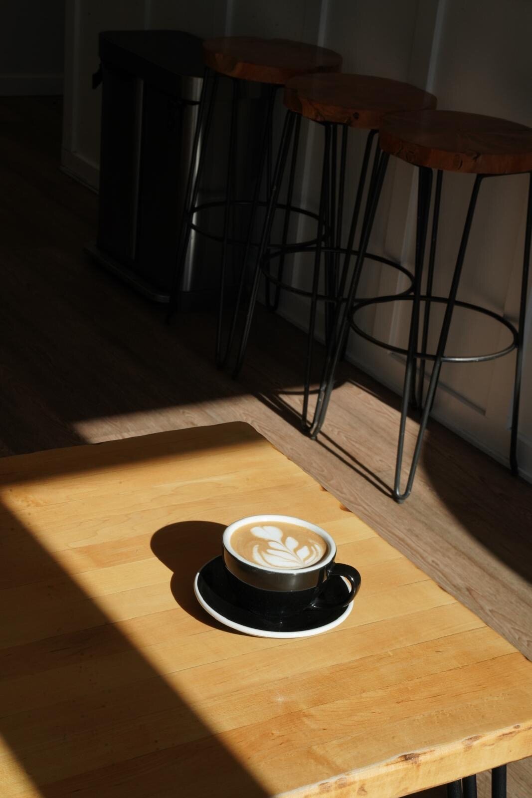 A latte on a sunlit table at Isaiah Café