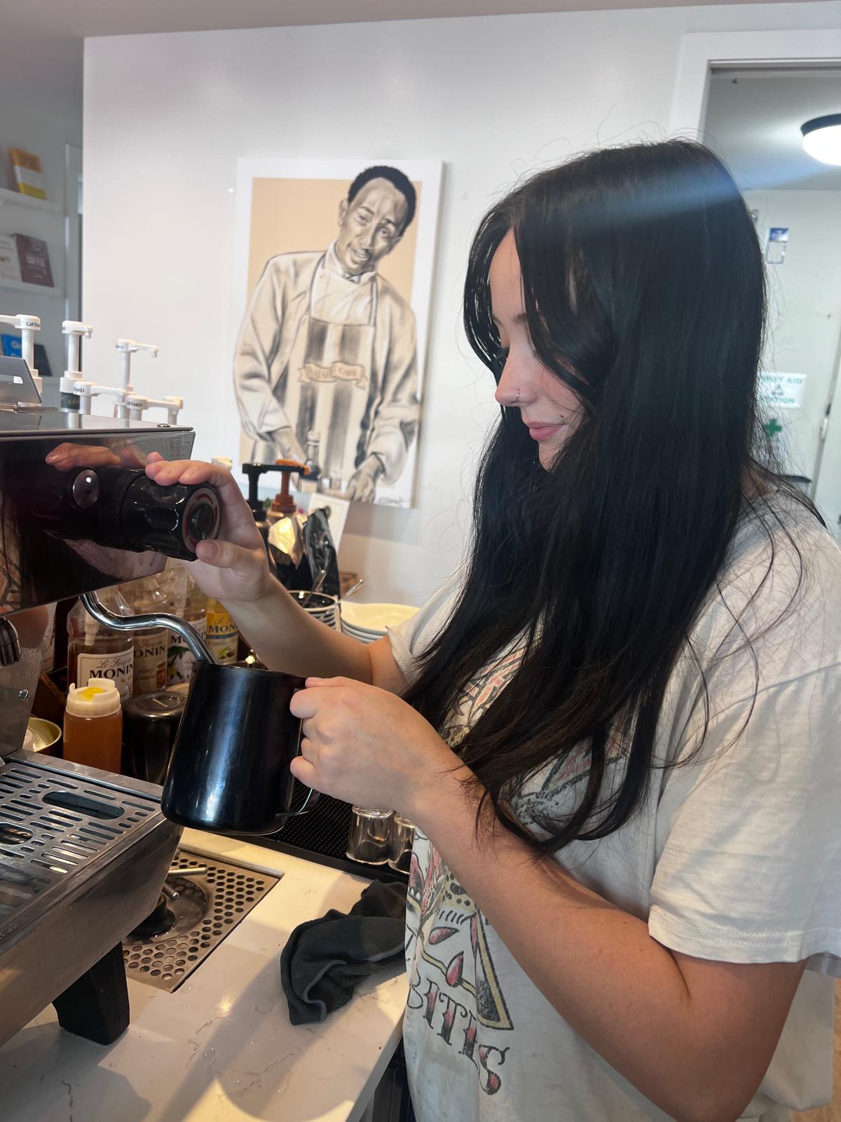 Paige steaming milk at the espresso machine